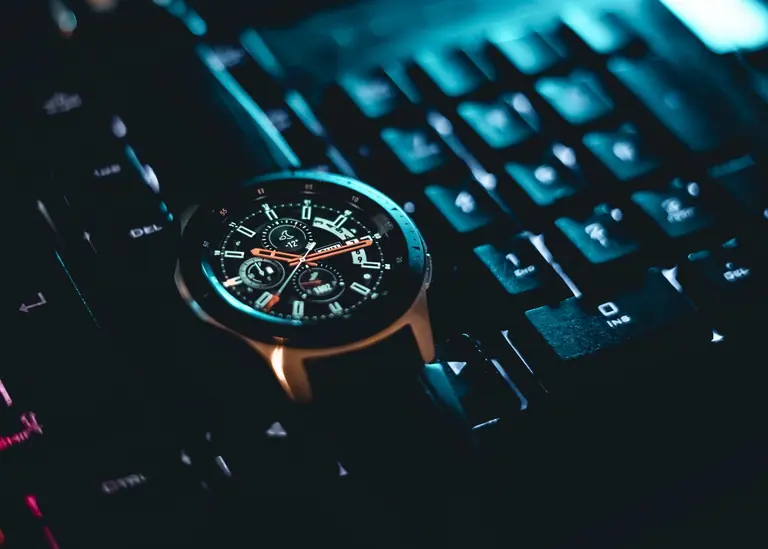 Close-up of a wristwatch on a computer keyboard. Perfect blend of technology and style.