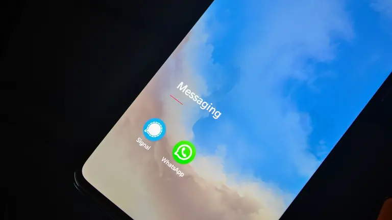 Close-up of smartphone screen showing Signal and WhatsApp messaging apps.