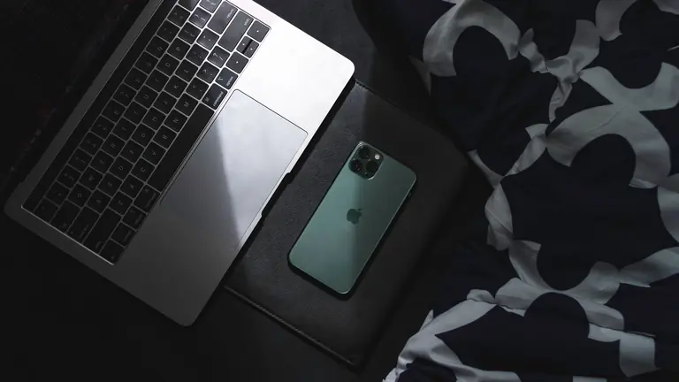 A sleek laptop and smartphone resting together. Ideal for technology and lifestyle themes.