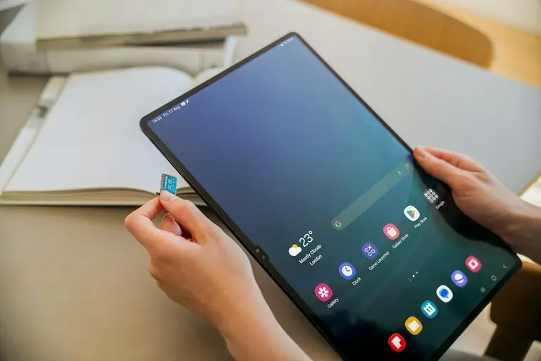 A person sitting at a table with a tablet