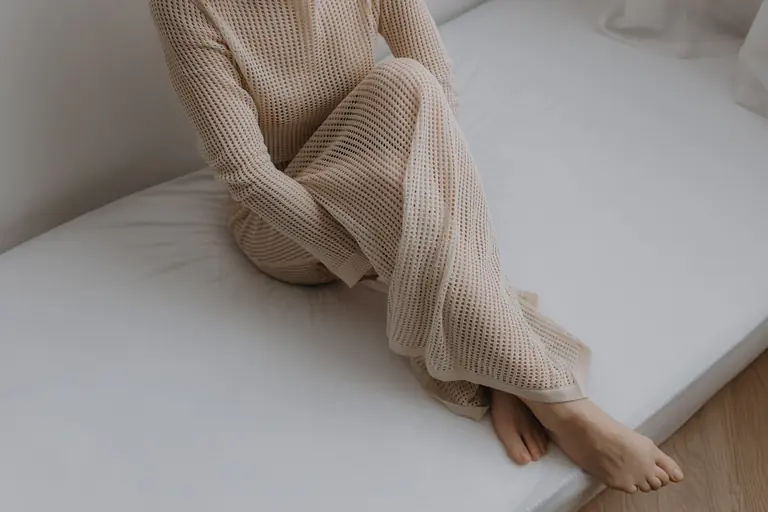 Portrait of a woman in a beige dress with minimalist style and serene pose.