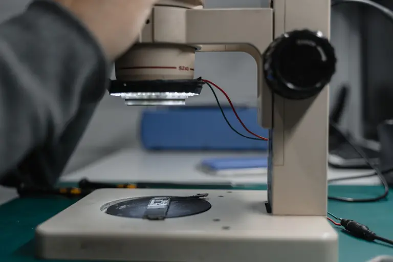 Detailed view of a microscope used in electronic device examination in a lab setting.