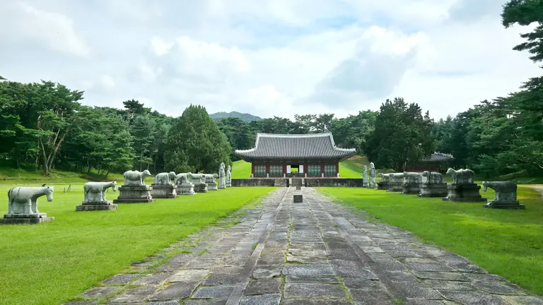 A serene temple surrounded by stone statues and lush greenery in South Korea.