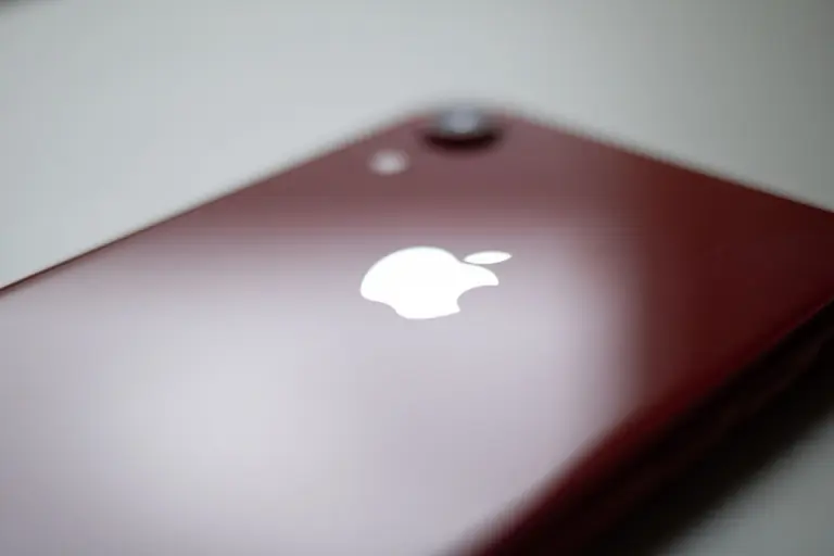 A red smartphone showcasing a sleek design with its iconic logo, focused on technology.
