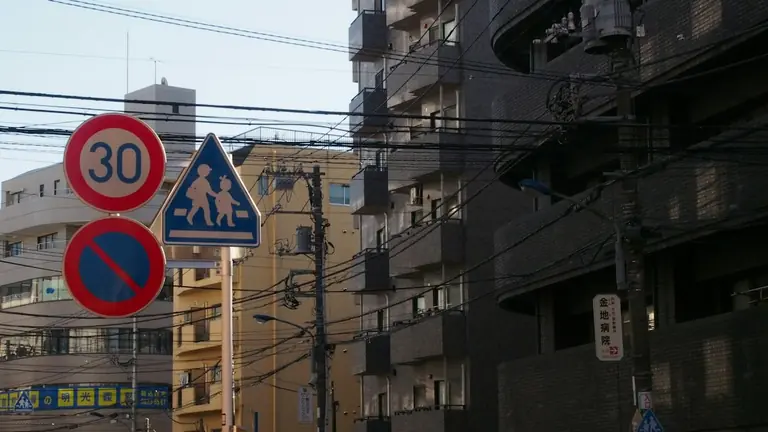 Urban street with buildings, utility poles, and traffic signs