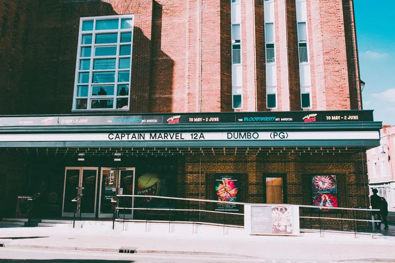 Historic cinema facade displaying movie posters of Captain Marvel in Chester, UK.