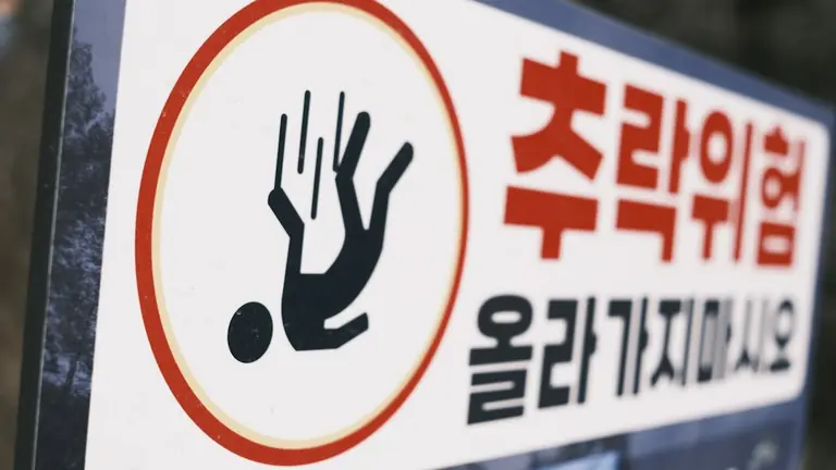 Warning sign for slipping hazard with falling person icon.